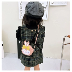 Fillette portant un sac bandoulière lapin rose avec une robe à carreaux chic