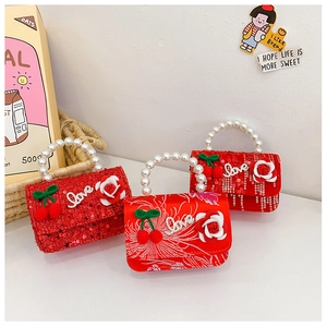 Detail of red sequin and silk kids handbags with pearl handles and cherry charms