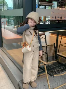 Dettaglio del set gilet e pantaloni in maglia beige con ricamo per bambini