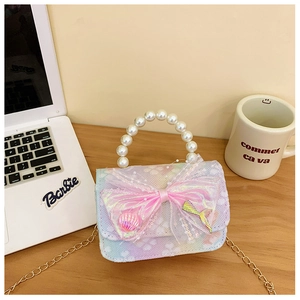 Detail of lace children handbag with pearl handle, bow, and mermaid tail charm