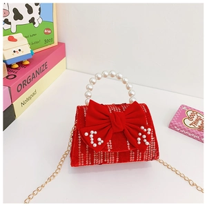 Detail of red velvet kids handbag with pearls, sequins and large bow decoration
