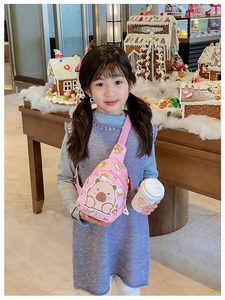 Pink child crossbody bag featuring cute Capybara print shown in a festive holiday setting
