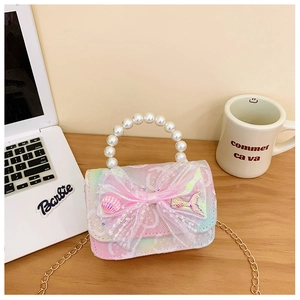 Detail of pink bow children purse with pearl handle and golden chain strap