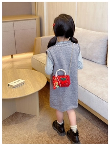 Close-up of red sequin children's bag with pearl handle and cherry decoration