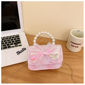 Detailed close-up of pink lace girl's handbag with large mesh bow and pearl handle