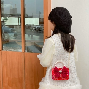 Red festive kids handbag with pearl handle, bow decoration and golden chain strap