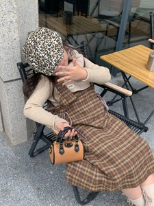 Scatto all'aperto di una bambina con una mini borsa a bauletto bicolore e outfit moda