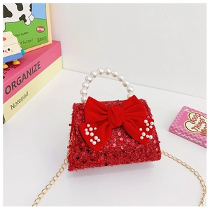 Detail of red sequin girls purse with pearl handle and velvet bow decoration