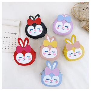 Vue à plat de mini-sacs lapin de dessin animé colorés avec oreilles 3D et nœuds