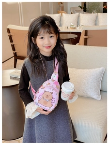 Sac bandoulière enfant tie-dye rose avec motif ours porté par un enfant au café