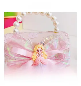 Detail of pink girls handbag with pearl handle, sequin lace and princess doll ornament