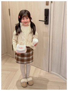 Détail d'une jupe à carreaux pour fille avec sac en peluche à perles et tenue d'automne