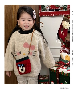 Close-up of red crochet dog crossbody bag and fleece sweatshirt on girl with Christmas props