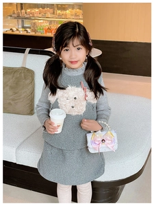 Detailed view of girls grey knit dress with white plush dog applique and red plaid bow