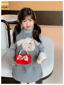 Detail of red sequined girl's handbag with large bow, Snow White badge, and pearl handle