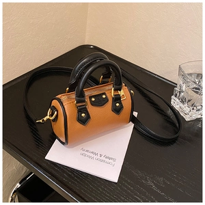Dettaglio mini borsa Boston in pelle marrone con manici neri e cerniera in metallo dorato