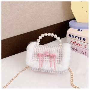 Détail du sac en tweed rose à carreaux avec poignée en perles, fourrure et fleurs en satin