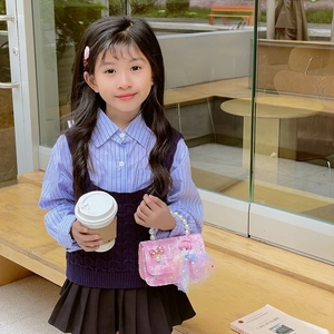 Sweet pink tweed girls' handbag with pearl handle and bow, shown by child model