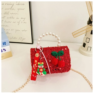 Detail of red sequin kids bag with pearl handle and knitted cherry decor for Lunar New Year