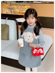 Detail showing high-quality gray knitted sweater with white puppy patch and red bow detail