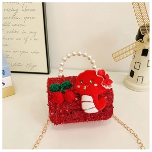 Detail of red sequined girls bag with pearl handle and plush snake charm decoration