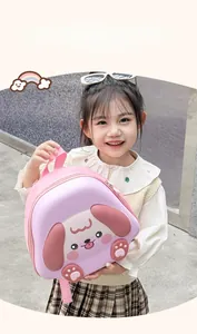 Pink dog-themed toddler backpack with 3D ears shown on a young girl outdoors