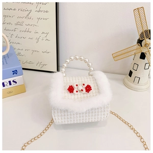 Détail du sac à main enfant avec poignée en perles et bordure en fausse fourrure douce
