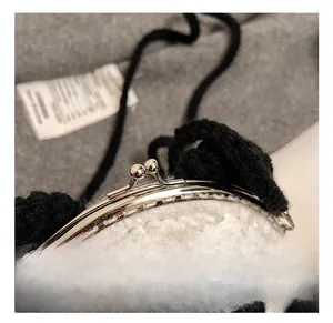 Close-up of the vintage silver kiss lock clasp on a knitted panda shoulder bag