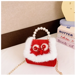 Détail du sac rouge tissé pour enfant avec poignée perle, fausse fourrure et chaîne dorée
