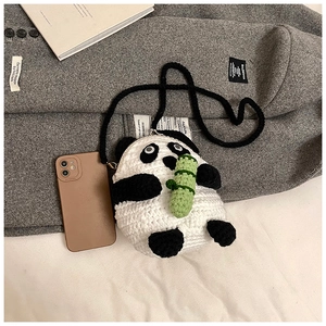 Detail of a handmade crochet panda crossbody bag with bamboo decoration and metal clasp