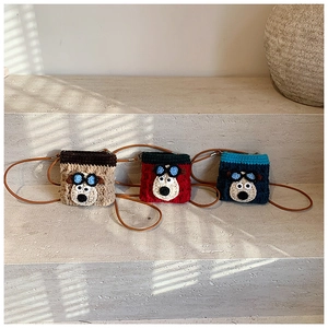 Detailed macro of handmade crochet mini crossbody bags featuring cute 3D cartoon bear faces
