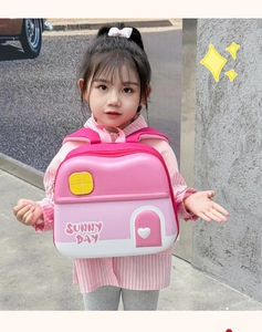 Detailed outdoor shot of a pink 3D house-shaped toddler backpack with heart door design