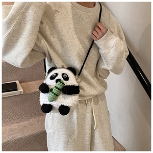 Detail showing hand-crocheted panda crossbody bag with bamboo and metal clasp