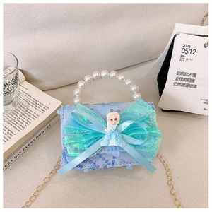 Detail of light blue girls' shoulder bag with pearl handle and cartoon doll ornament