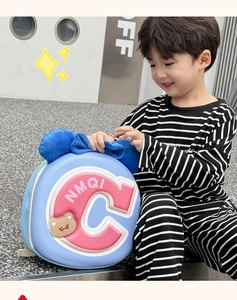 Detail of blue kid backpack featuring 3D pink C letter and cute bear motif for toddlers