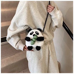 Detail of panda crochet crossbody bag with metal kiss-lock closure and bamboo charm