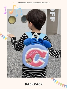 Detail showing the large pink 'C' logo and plush blue bow on a cute children's backpack