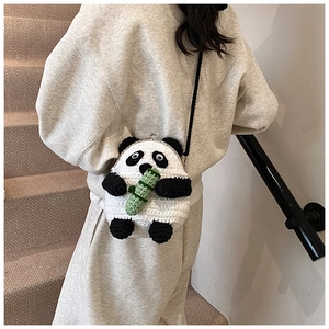 Detail showing hand-knitted panda crossbody bag with vintage silver metal clasp closure