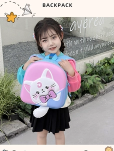 Pink and blue cartoon cat backpack with a fluffy tail shown on a young child outdoors