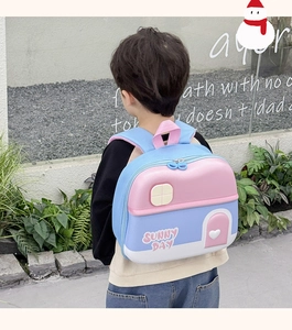 Outdoor shot of a child wearing the 3D house-shaped EVA hardshell backpack in pink and blue