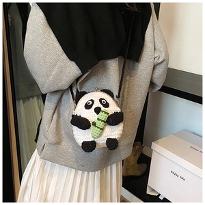 Close-up of handmade panda crochet crossbody bag with green bamboo and metal clasp detail