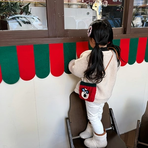 Handmade crochet puppy crossbody bag for kids featuring a festive red and green knit design