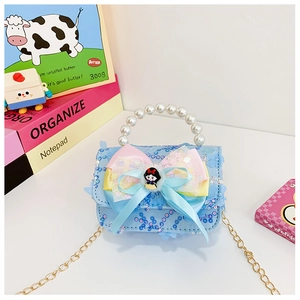 Close-up of glittery blue kids handbag with large organza bow and pearl handle detail