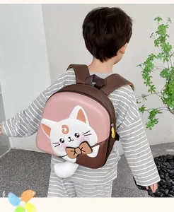 Close-up of pink hardshell kids backpack with a 3D cat face and plush tail detail