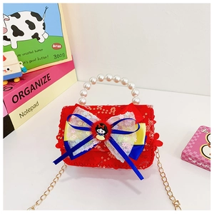 Detailed macro of red sequin kids bag with pearl handle and Snow White bow decoration