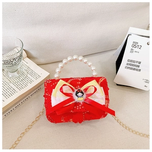 Detail of red sequined girl handbag with large bow, Snow White doll, and pearl handle