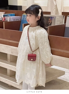 Detailed embroidery on white lace dress sleeve and mini red quilted chain bag