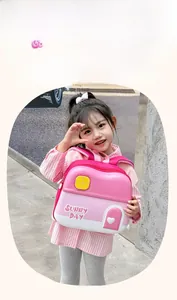Detail of a pink house-shaped EVA children's backpack with 'SUNNY DAY' print