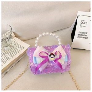 Detail of sequin kids handbag with pearl handle, bow, and cartoon character decor