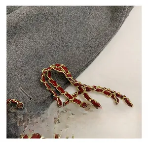 Detail of burgundy leather and gold metal braided chain strap for children handbag
